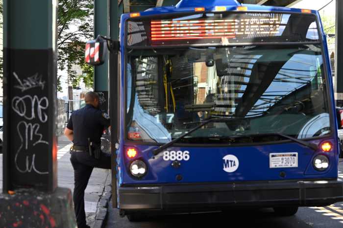 police officer standing at entryway on to a Brooklyn bus