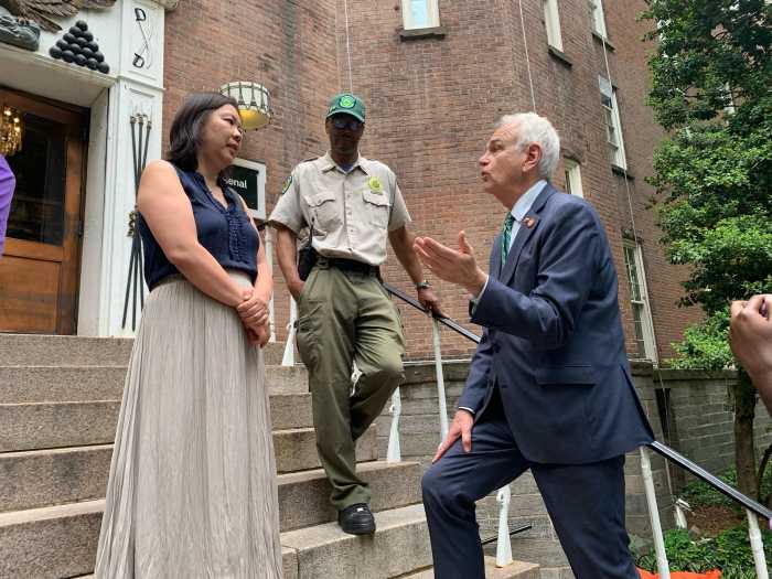 two men and a woman on steps at a NYC park.