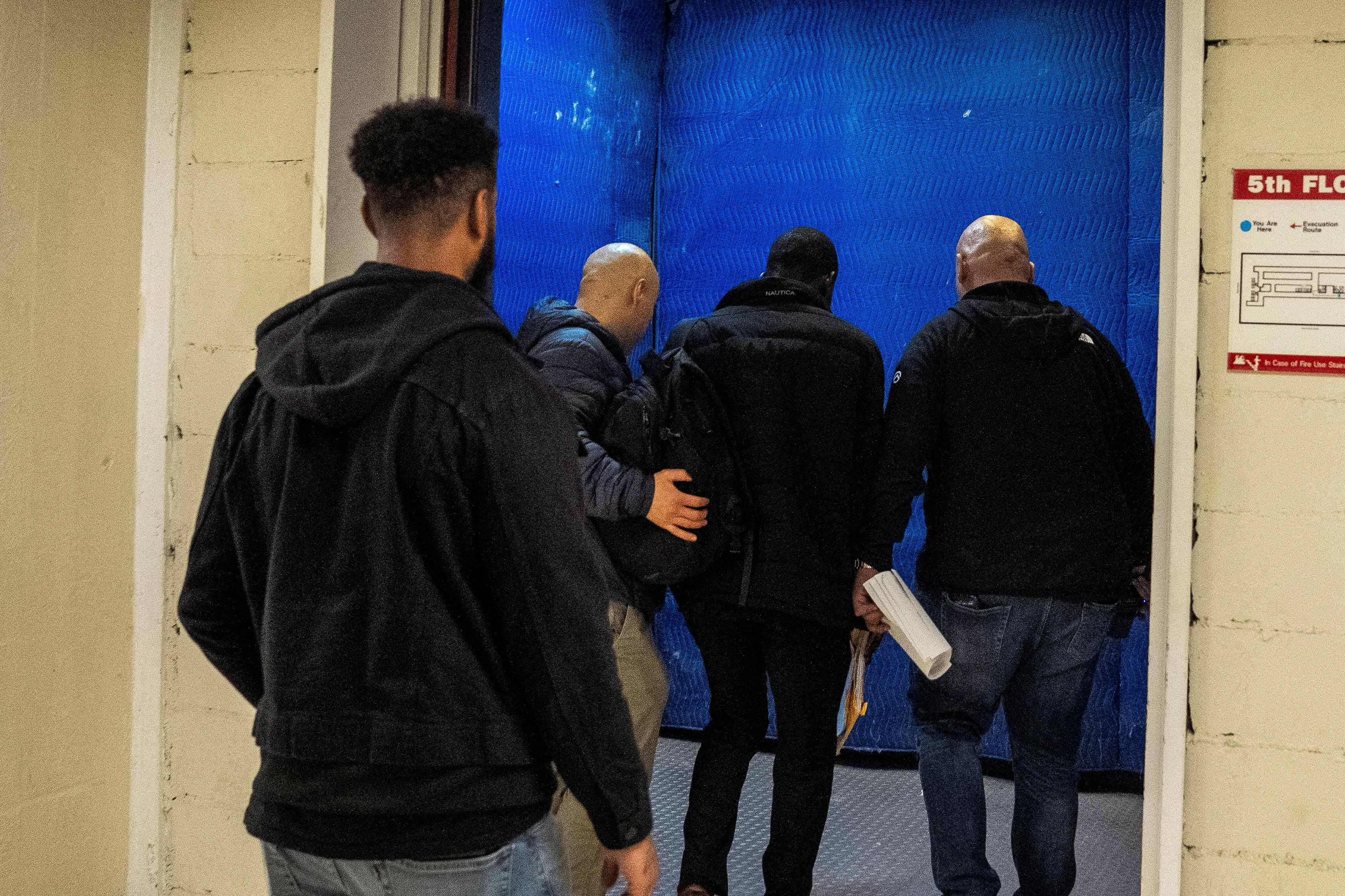 group of men in front of a blue background