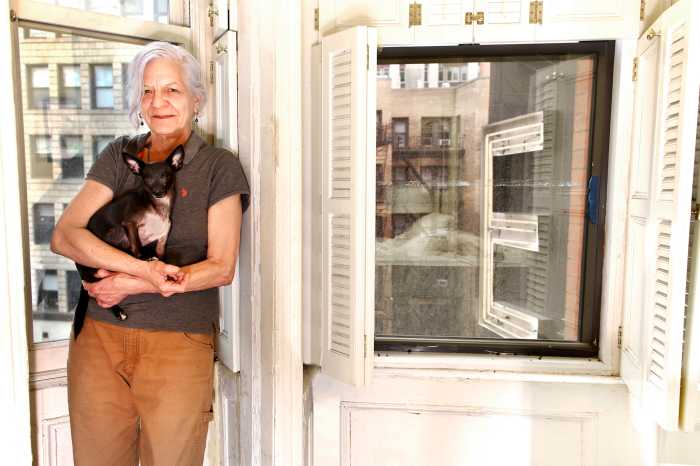 Artist Michele Zalopany holding dog at Hotel Chelsea
