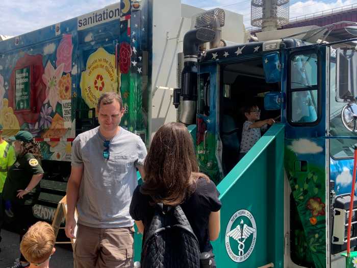 Enjoy a truck-load of fun on Randall's Island this Saturday 2 sanitation truck during the day with people standing next to it