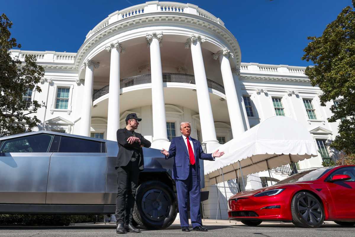 FILE PHOTO: U.S. President Donald Trump talks to the media next to Tesla CEO Elon Musk, with Tesla cars in the background, at the White House in Washington, D.C., U.S., March 11, 2025. REUTERS/Kevin Lamarque/File Photo