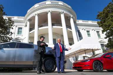 FILE PHOTO: U.S. President Donald Trump talks to the media next to Tesla CEO Elon Musk, with Tesla cars in the background, at the White House in Washington, D.C., U.S., March 11, 2025. REUTERS/Kevin Lamarque/File Photo