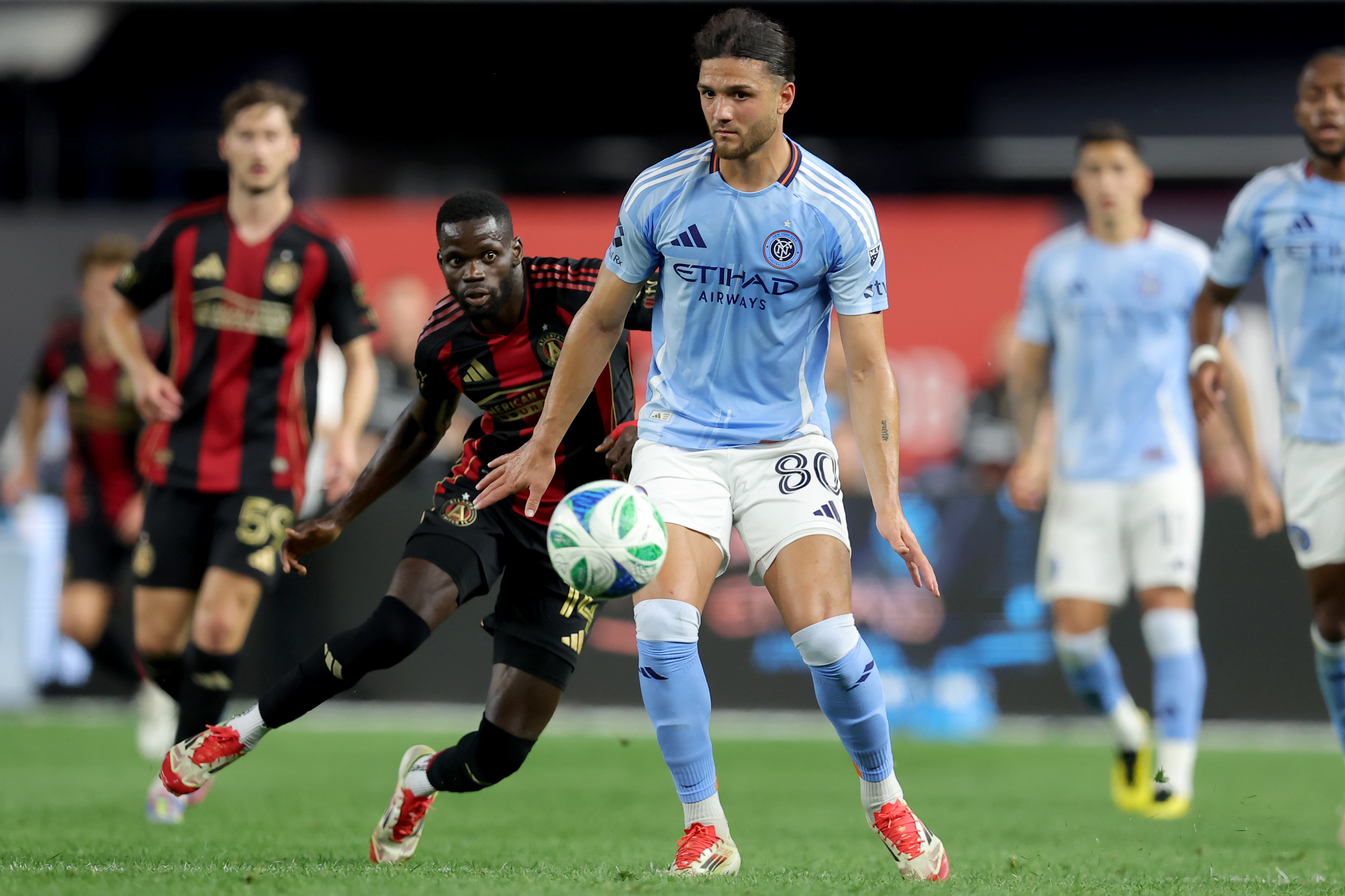 Jun 12, 2025; New York, New York, USA; New York City FC midfielder Justin Haak (80) controls the ball against Atlanta United forward Jamal Thiare (14) during the second half at Yankee Stadium. Mandatory Credit: Brad Penner-Imagn Images