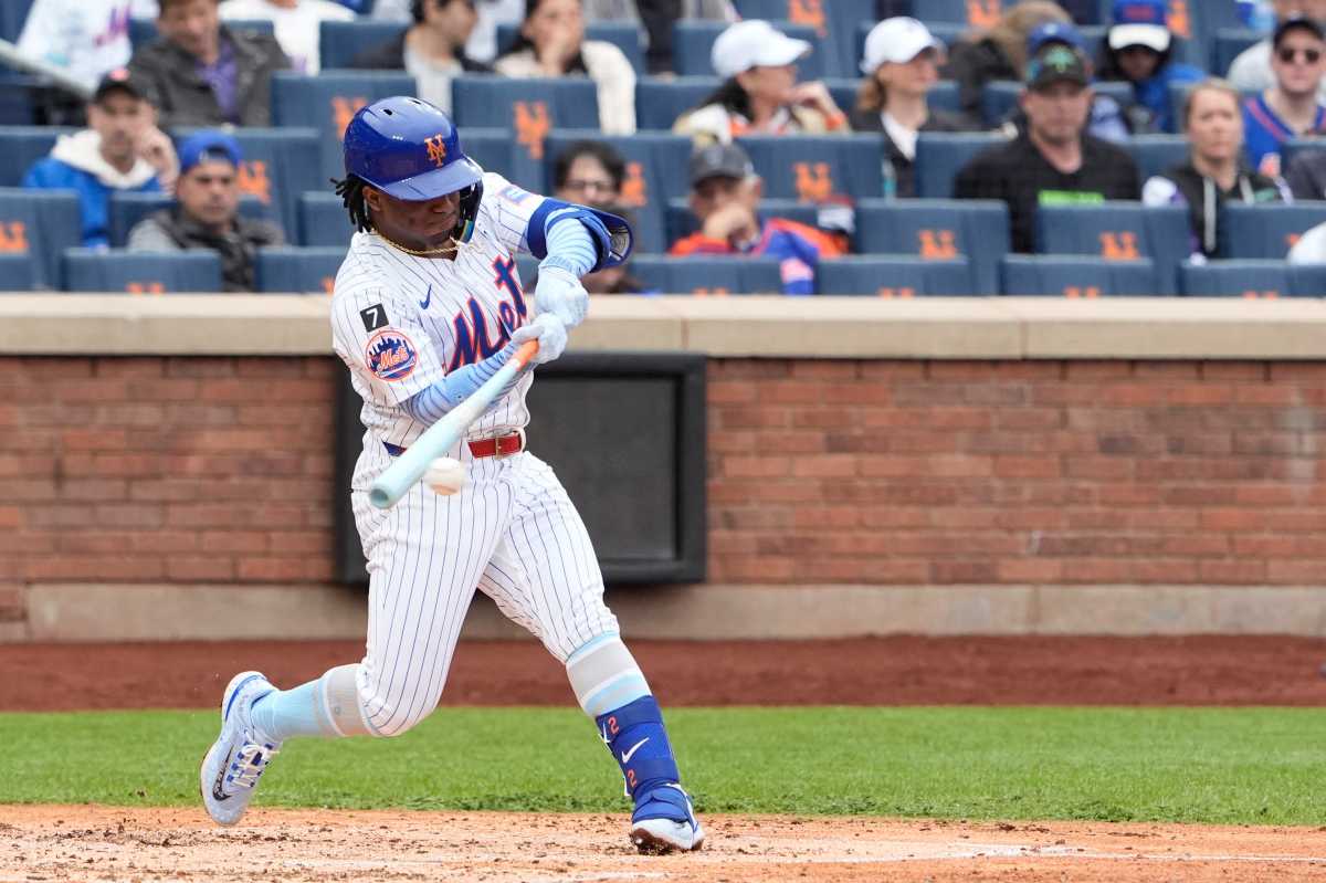 Mets player swings bat and hits single