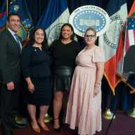 NYC Council resolution brings slain NYPD Detective Familia's family closer to pension justice 29 four people on a stage next to a photo of an NYPD officer