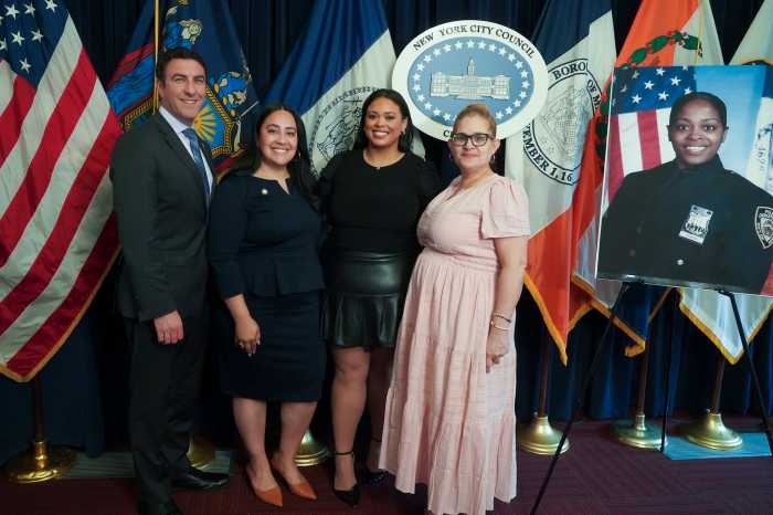 four people on a stage next to a photo of an NYPD officer