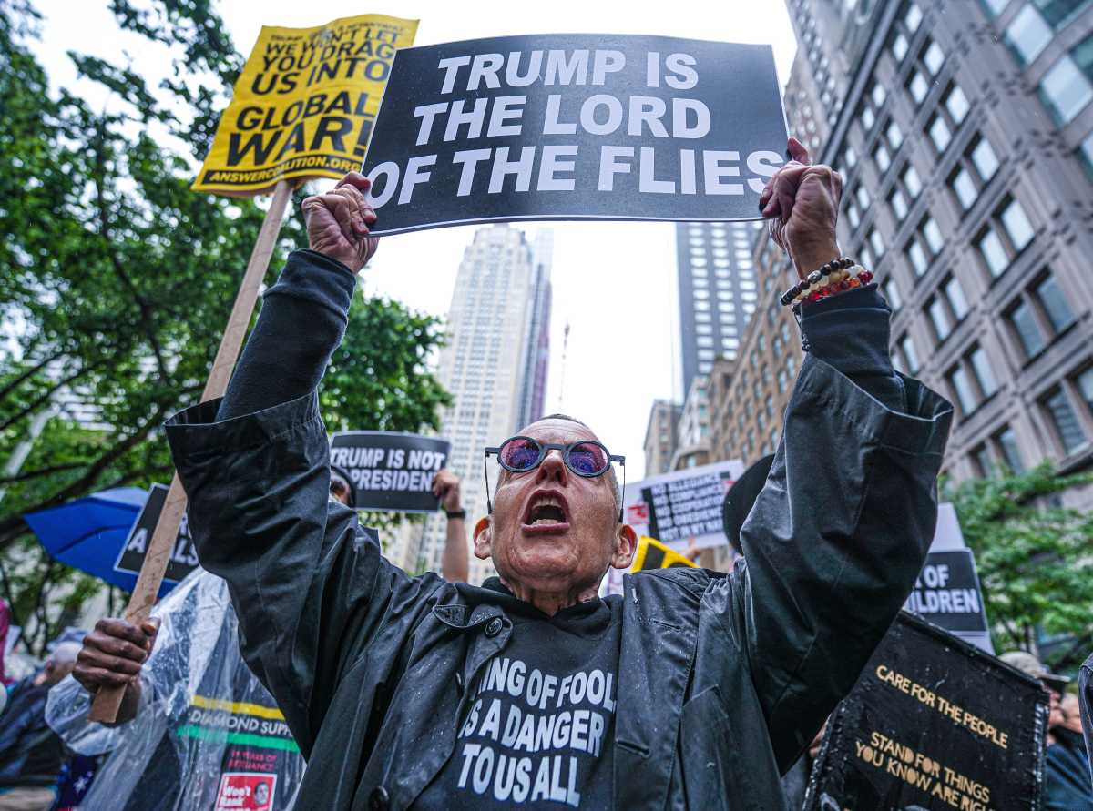 Person holds sign during No Kings Day march