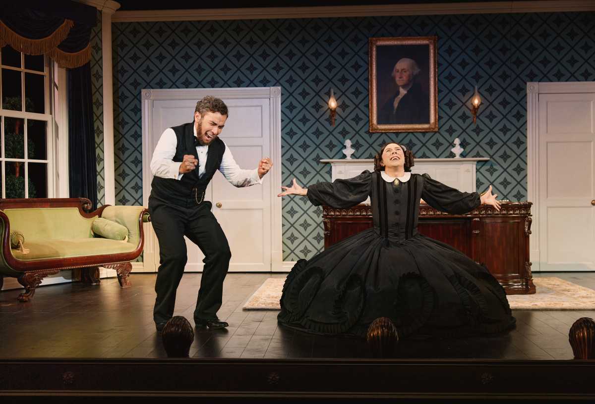 man dressed like abraham lincoln with actor dressed in 1850s dress arms outstretched