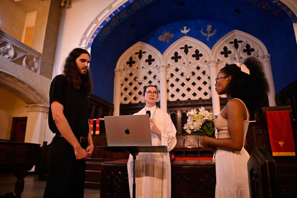 Maksim Reviaka, (left) stands next to his wife Akeelah while taking vows during their marriage cereomy at Second Presbyterian Church on Sunday, June 22. Reviaka is set to face a deportation hearing on July 1.
