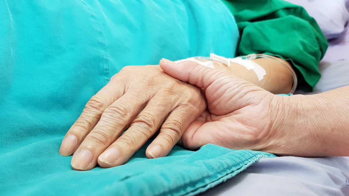 New York on the cusp of allowing medical aid in helping terminally ill die as state Senate sends controversial bill to Hochul's desk 2 Person holding hands of terminally ill patient