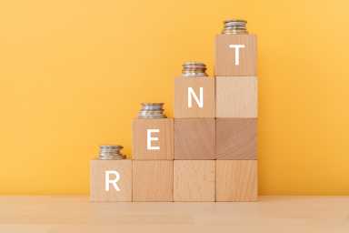 Wooden blocks with "RENT" text of concept and coins.