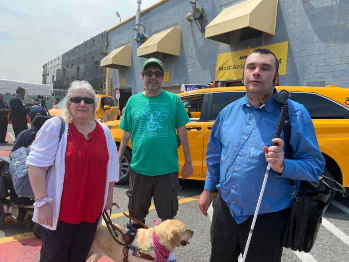 people outside with a brown dog at an event about NYC taxis.