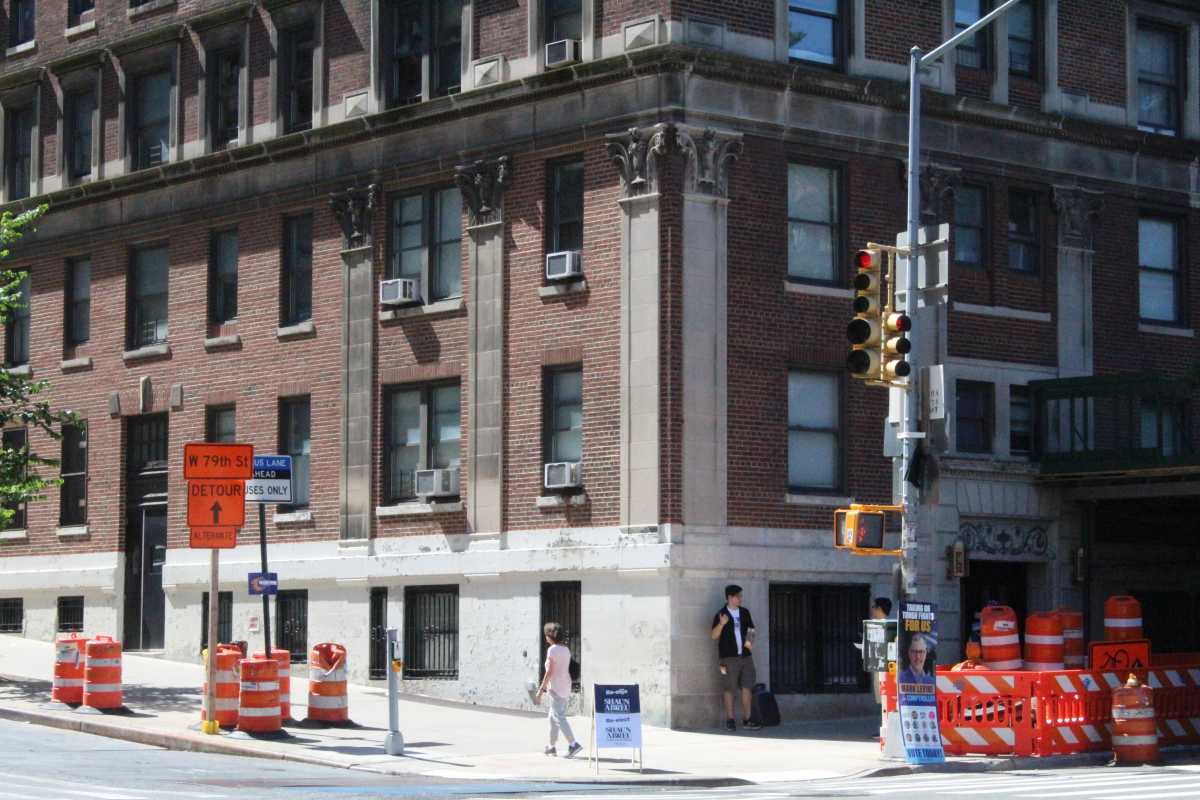 a man finds shade against a building in new york city during a heat wave