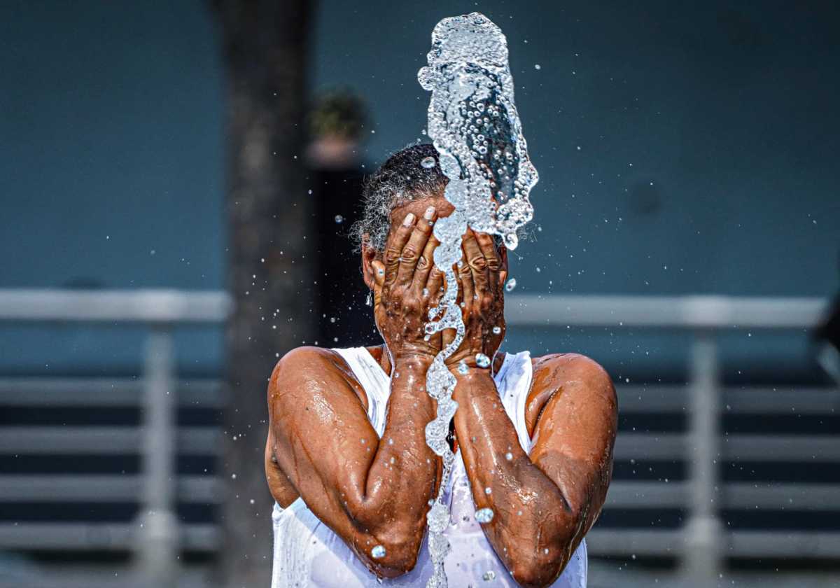 New Yorker splashing water on face during extreme heat wave