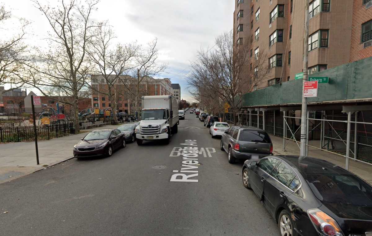 Street with cars and trucks near apartment building and park