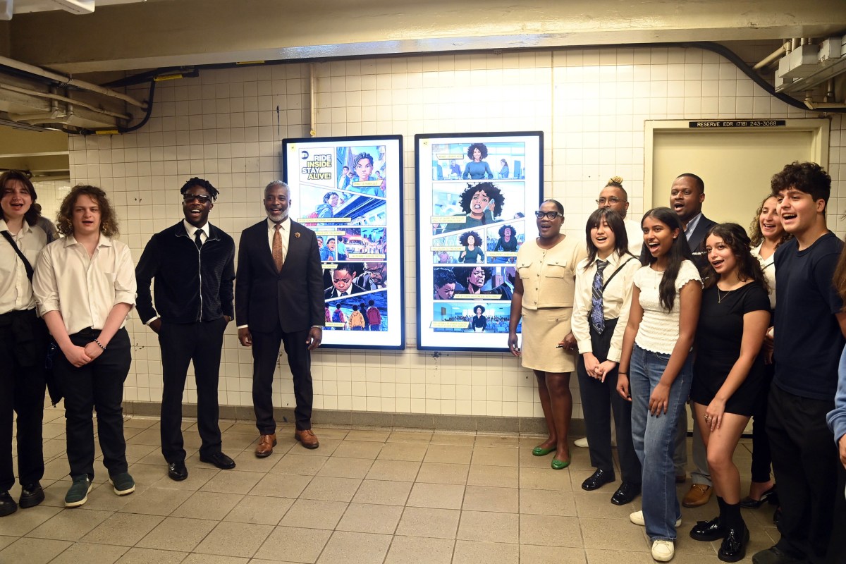 group of people standing next to a comic strip ad in a NYC subway station