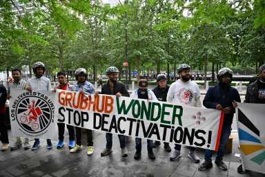 Delivery workers holding a sign that reads Grubhub wonder stop deactivations