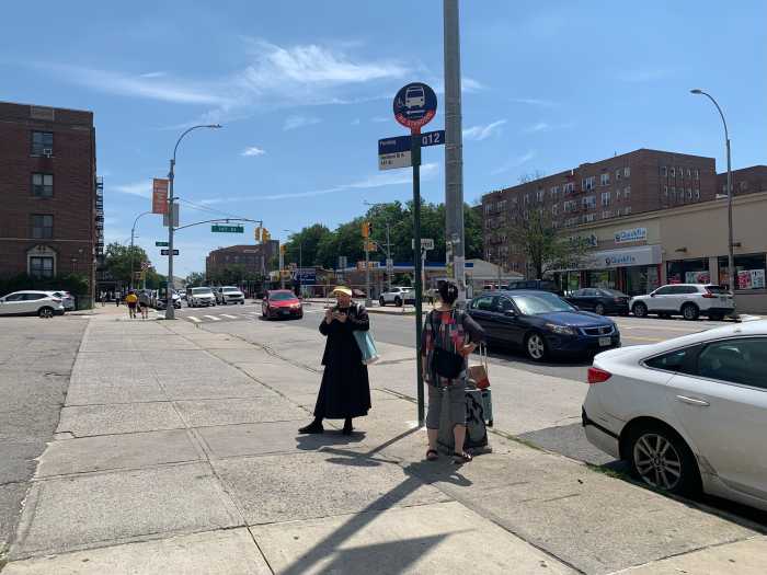 First day of massive Queens bus network redesign goes off mostly glitch-free in Flushing 2 people standing at a bus stop