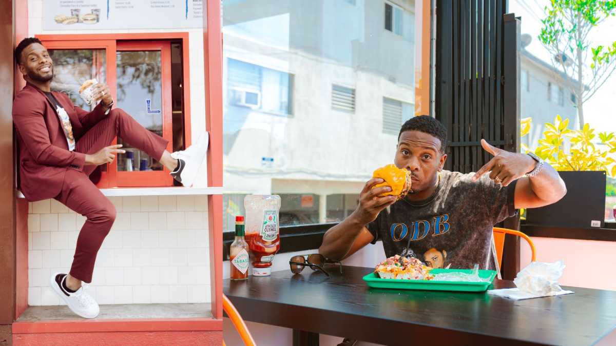 Kel Mitchell in two side by side photos pictured holding burgers to promote Kel's Burger Fest