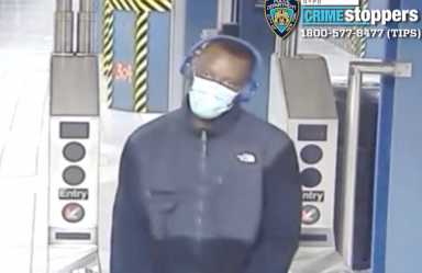 man with mask on face walking near subway turnstile