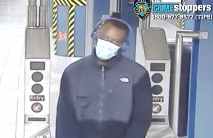 man with mask on face walking near subway turnstile
