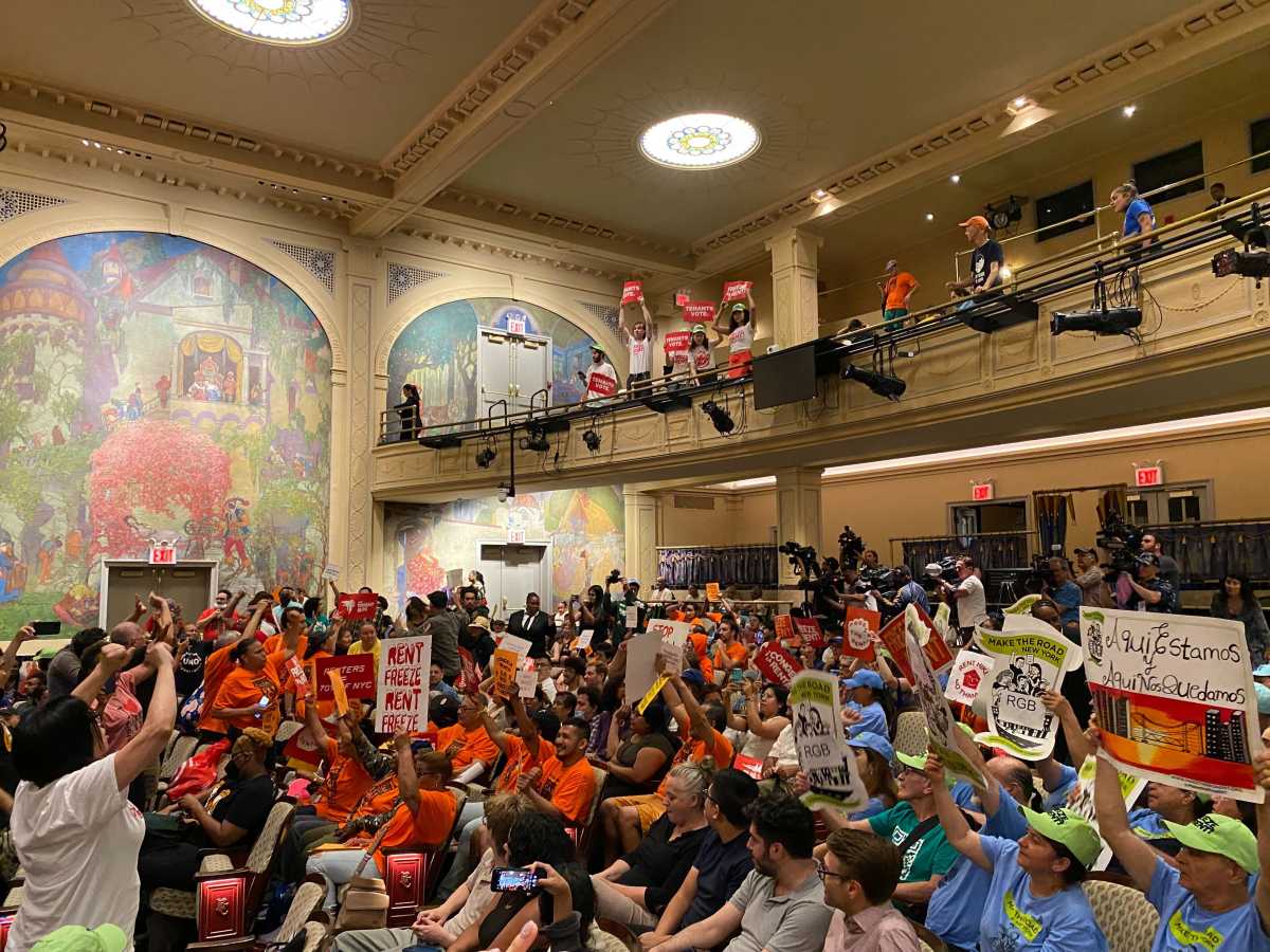 People seated in theater protesting rent increases