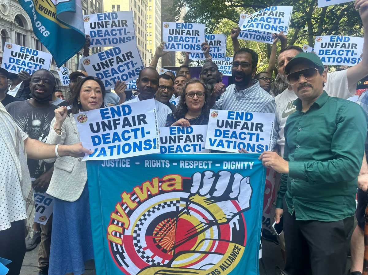 people gathered around a sign advocated for Uber and Lift drivers