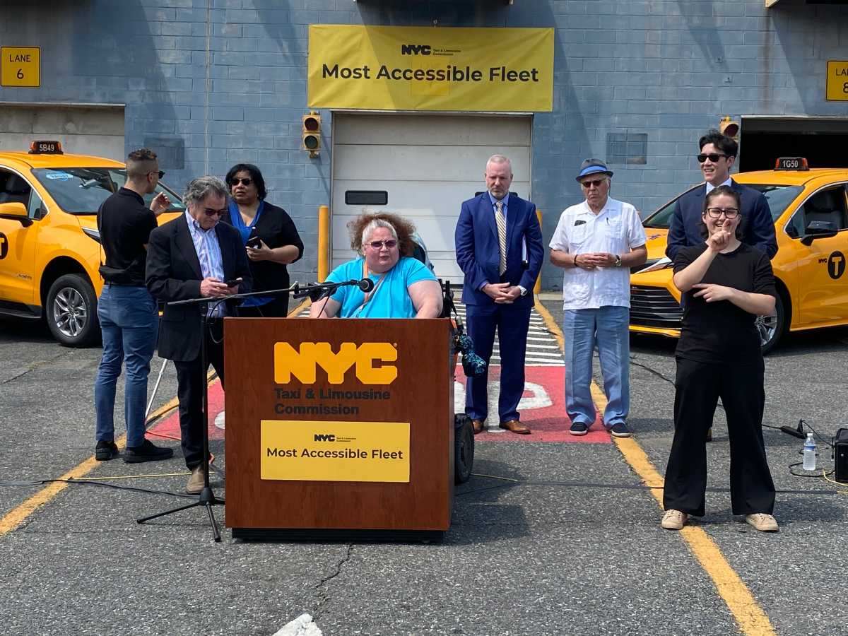 people outside at a podium at NYC taxis facility