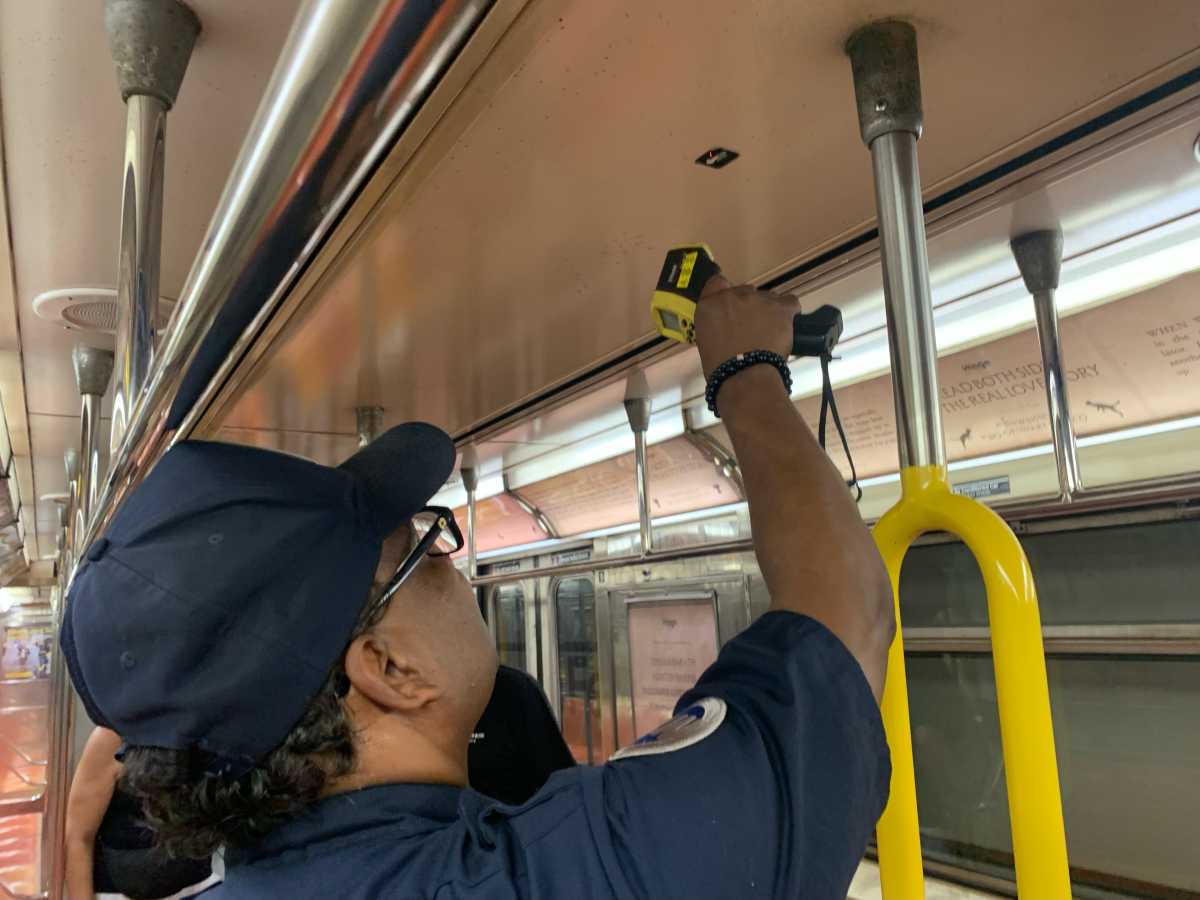 man taking the temperature on a rail car of one of many MTA subways