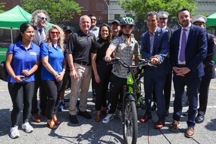 group of people outside in NYC around an e-bike discussing safety topics about e-bikes