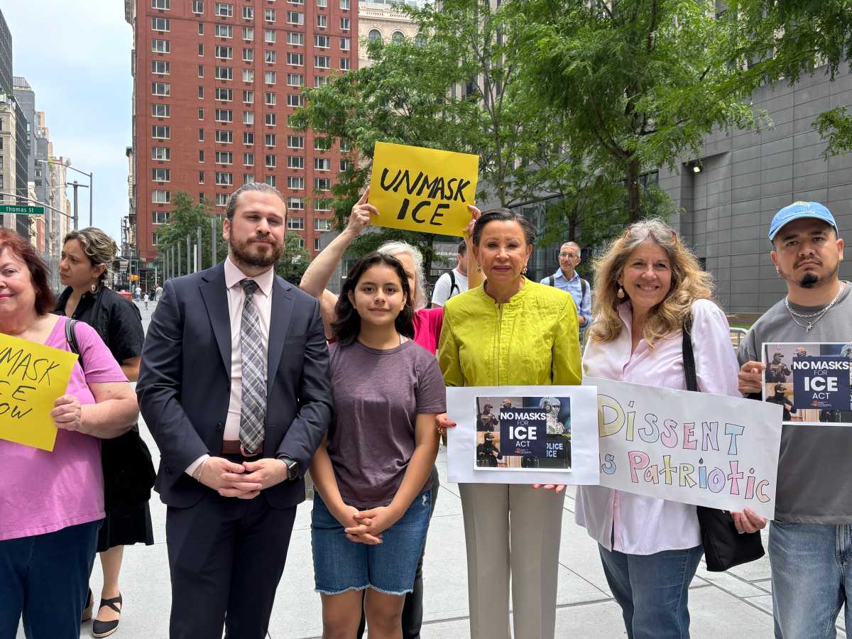 men and women holding up signs urging end to ICE agents wearing masks