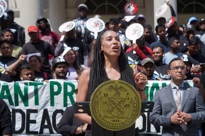 Council Member Sandy Nurse speaks on the steps of City Hall during a rally with Los Deliveristas Unidos in support of the Grocery Delivery Worker legislative package, joined by Council Members Shaun Abreu and Jennifer Gutiérrez,