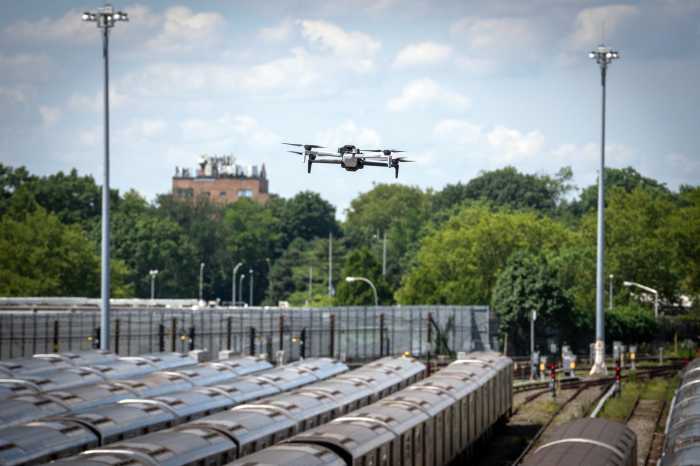 A police drone over subway cars on tracks in effort to stop subway surfing