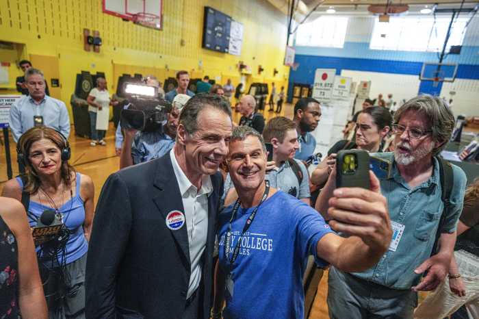people smiling at campaign event as candidate Cuomo poses for photo with woman