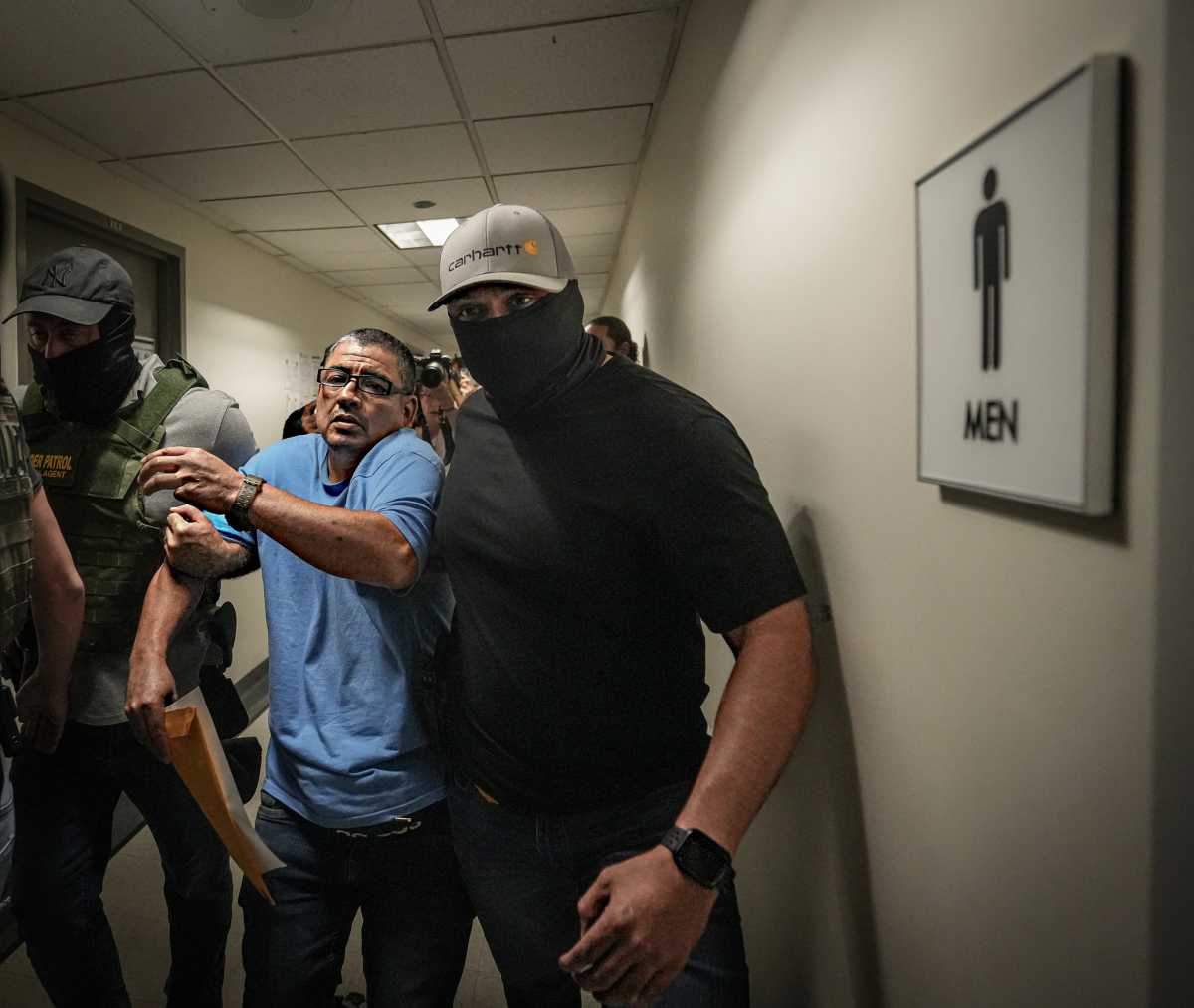 Masked guards for ICE escort immigrant