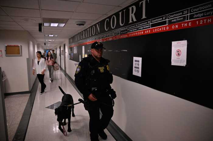 A DHS officer patrols the halls of the 12th floor alongside a K9 