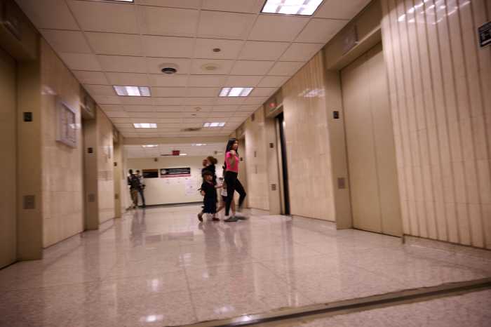 A mother and her children exit the 12th floor of the federal building 