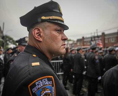NYPD officer staring at funeral for fallen cop
