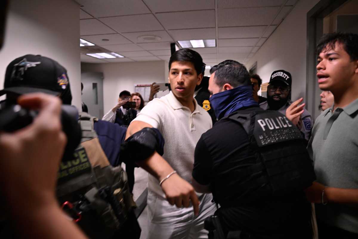 ICE agents escort a man through the hallway of 26 Federal Plaza following a court hearing.