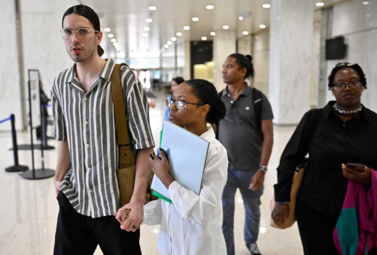 Man and woman holding form while walking inside immigration court