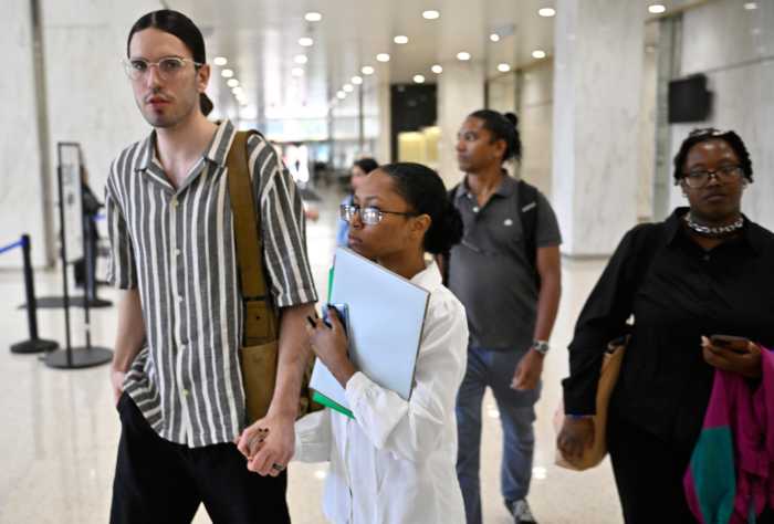 Man and woman holding form while walking inside immigration court