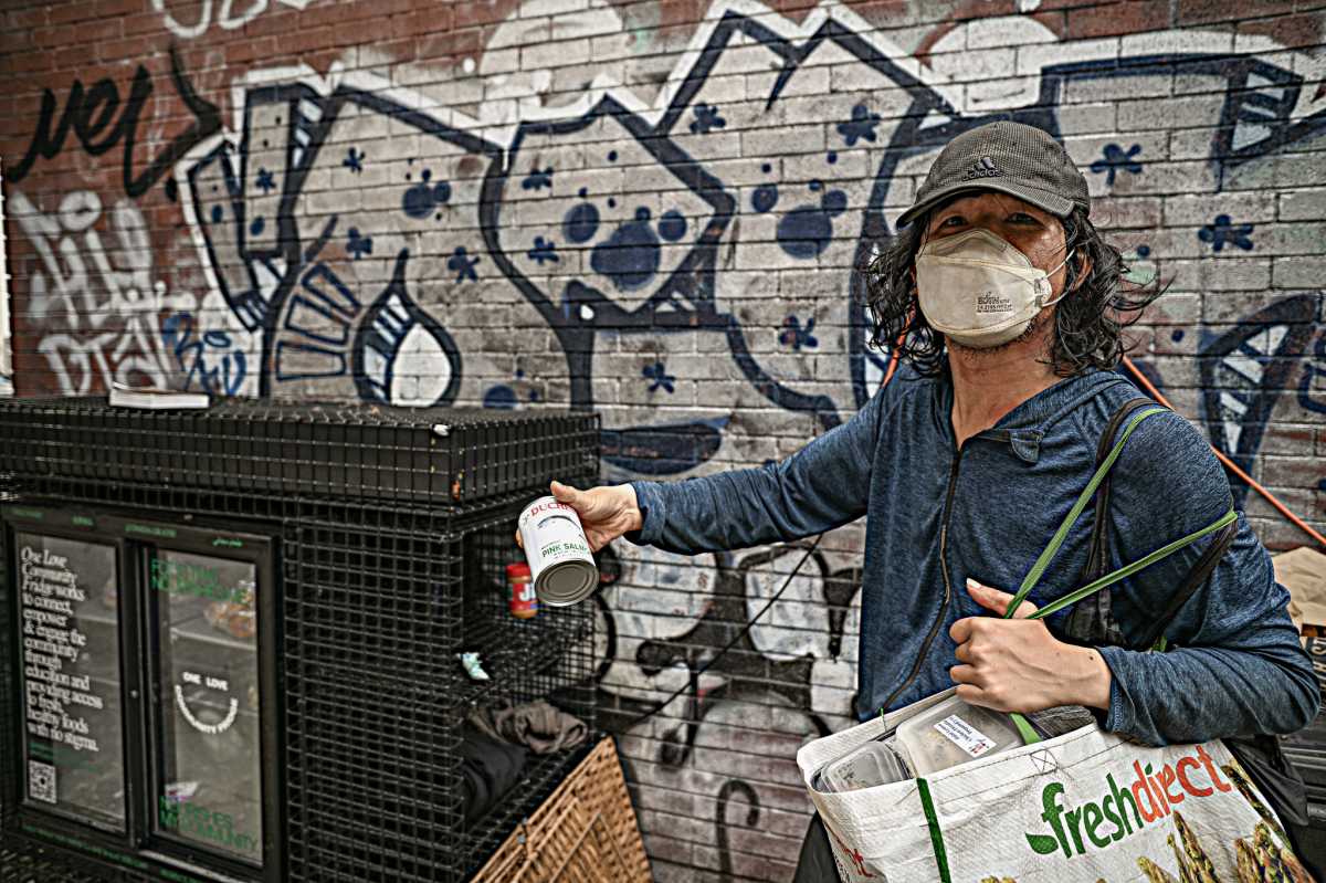 Woman standing next to community fridge in Manhattan