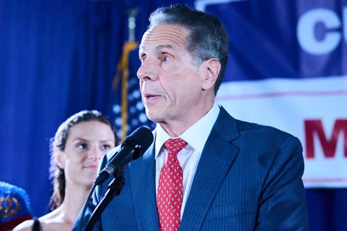 man at Cuomo campaign rally speaking with suit and tie on