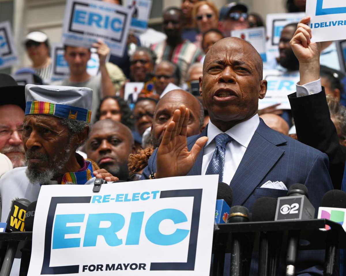 NYC Mayor's Race: Cuomo makes his independent bid for mayor official, says he's 'in it to win it' 2 man speaking at podium while wearing suit with sign reading ERIC adams for mayor