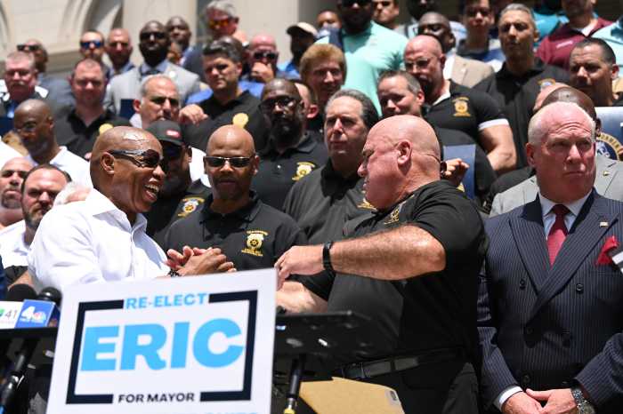 Mayor Eric Adams stands with law enforcement and sanitation union leaders during a rally on the steps of City Hall, Thursday.