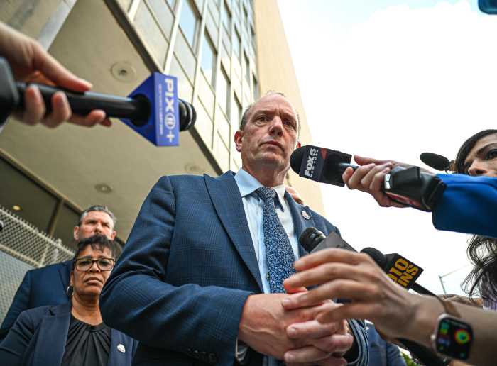 NYPD police union head speaks to people holding microphones