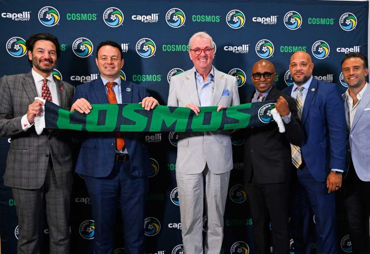 Cosmos: Men in suits pose with scarf in front of dark blue backdrop