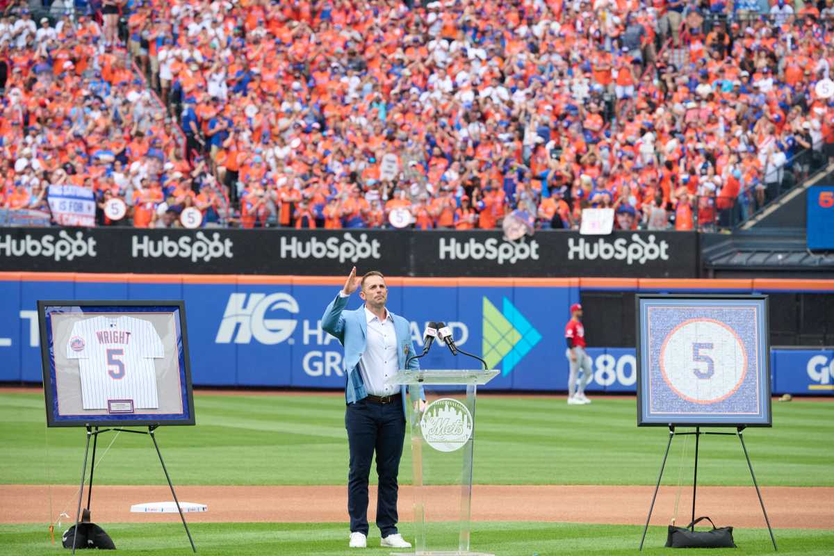David Wright: Man in blue suit stands on baseball field and gives speech to fans.