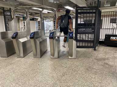 person wearing a backpack jumping a sturnstile in a Brooklyn subway station